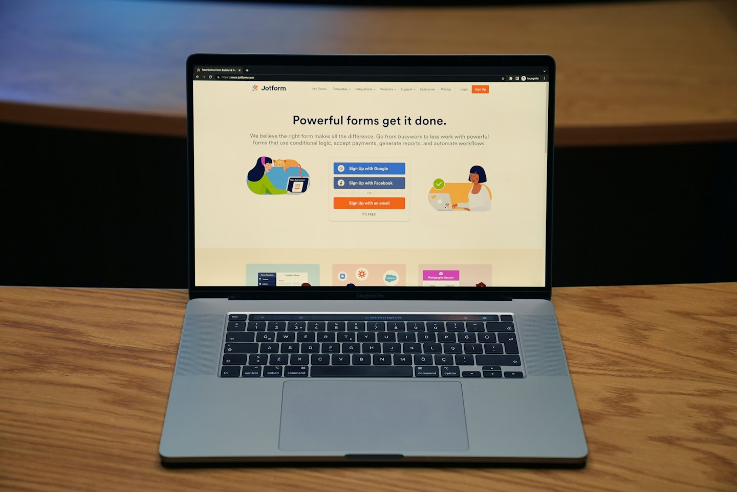Silbernes MacBook Pro mit Jotform auf einem Holztisch.